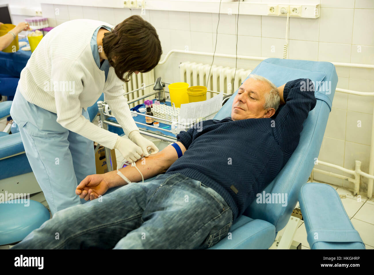 Sofia, Bulgaria - 23 dicembre 2016: un uomo dona il sangue in un ospedale durante una campagna per la donazione del sangue. L'infermiera perfora la mano del paziente vena di ne Foto Stock