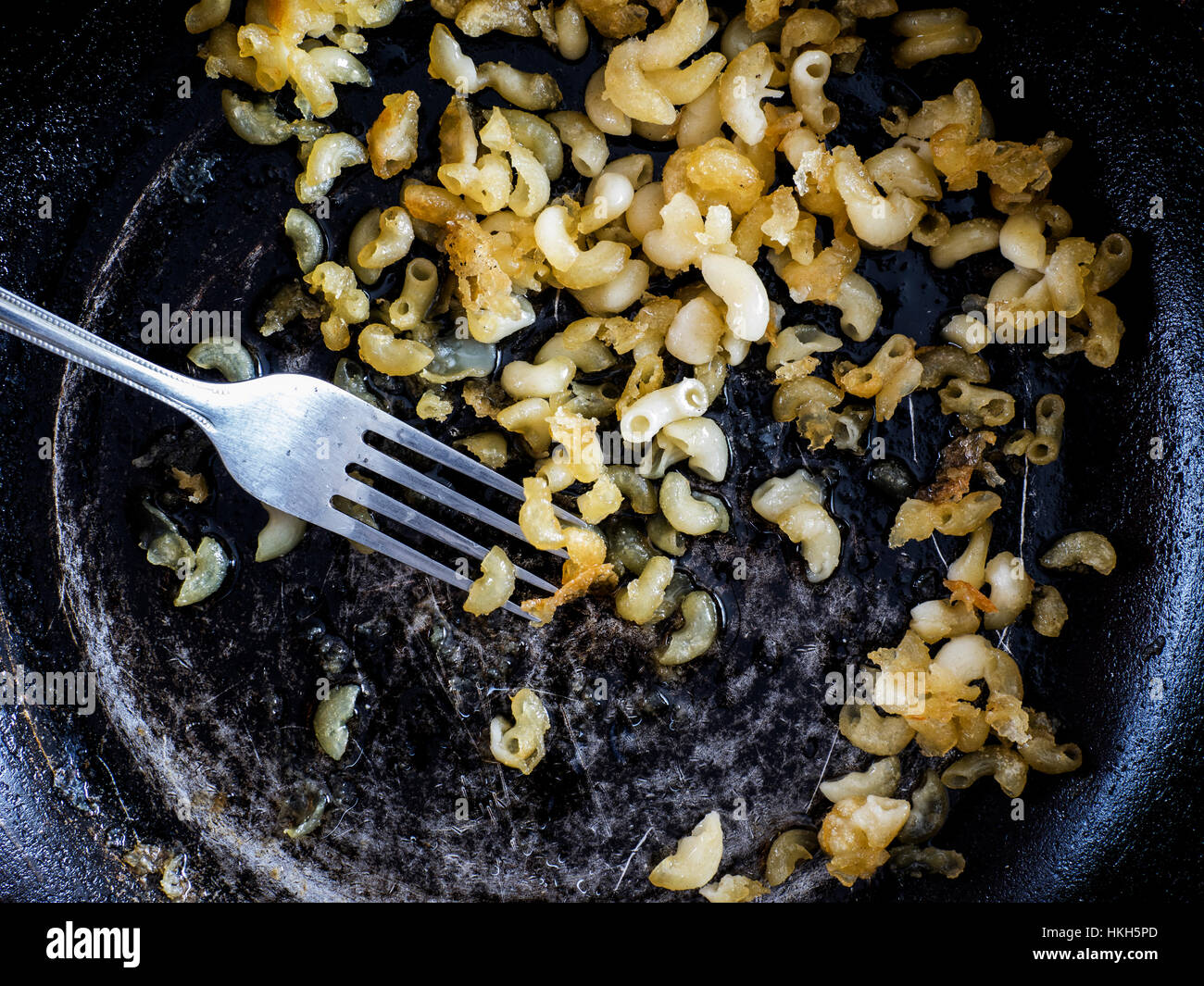 Guastato cibo: la pasta essiccata in una padella Foto Stock