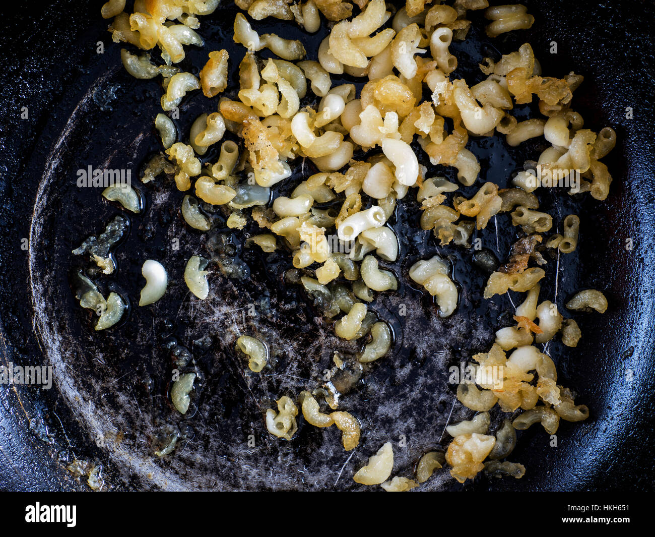 Guastato cibo: la pasta essiccata in una padella Foto Stock