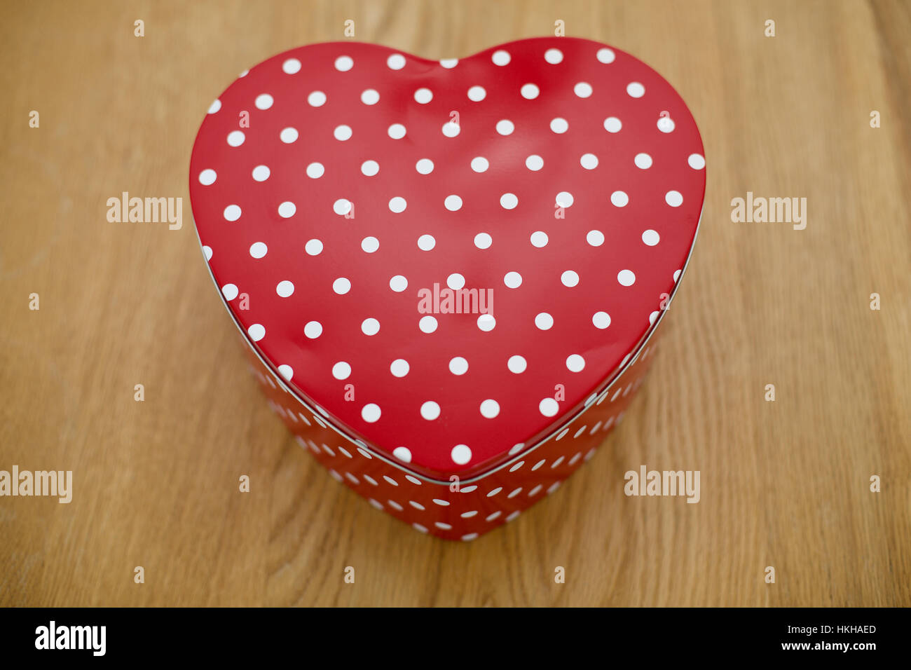 A forma di cuore a macchie rosse biscotto stagno su una tavola di legno dal di sopra per San Valentino Foto Stock