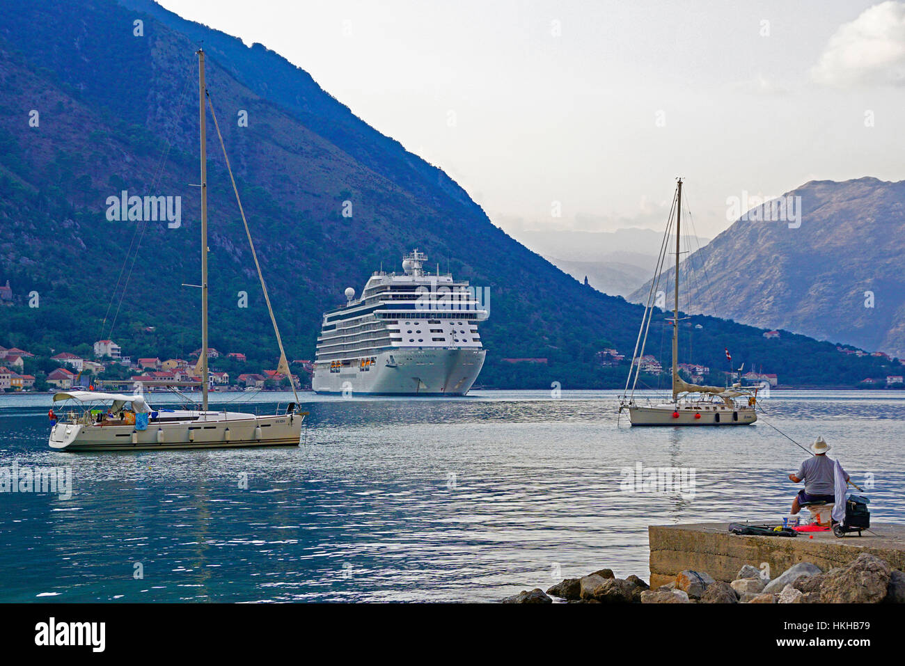 Regent's Seven Seas Explorer lussuosa nave da crociera con due barche a vela e fisherman nel porto di Cattaro. Foto Stock
