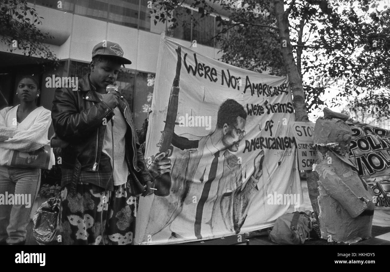 Afro-americano di protester parlando su un portatile del pubblico, altri tenendo un banner che mostra Malcolm X con un AK-47 fucile, durante una polizia brutalità dimostrazione a Oakland, in California, 1985. Credito Foto Collezione Smith/Gado/Getty Images. Foto Stock
