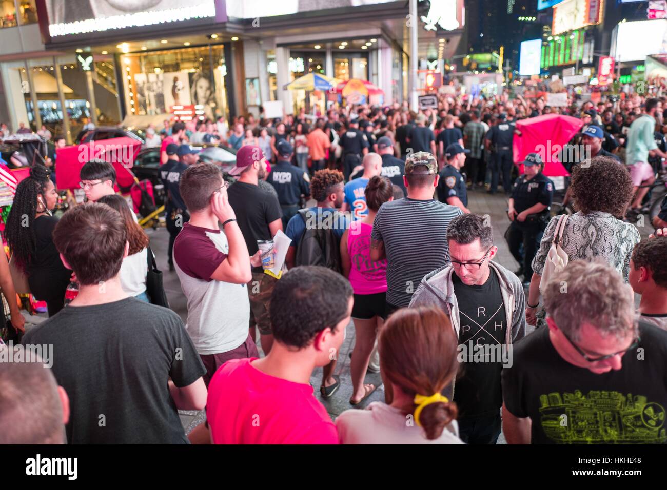 Durante un nero vive questione protestare in New York Times Square a seguito della morte di ripresa di Alton Sterling e Philando Castiglia, attivisti di bloccare il traffico e quadrato fuori contro una linea di New York Police Department (NYPD) polizia come turisti a guardare, 2016. Foto Stock