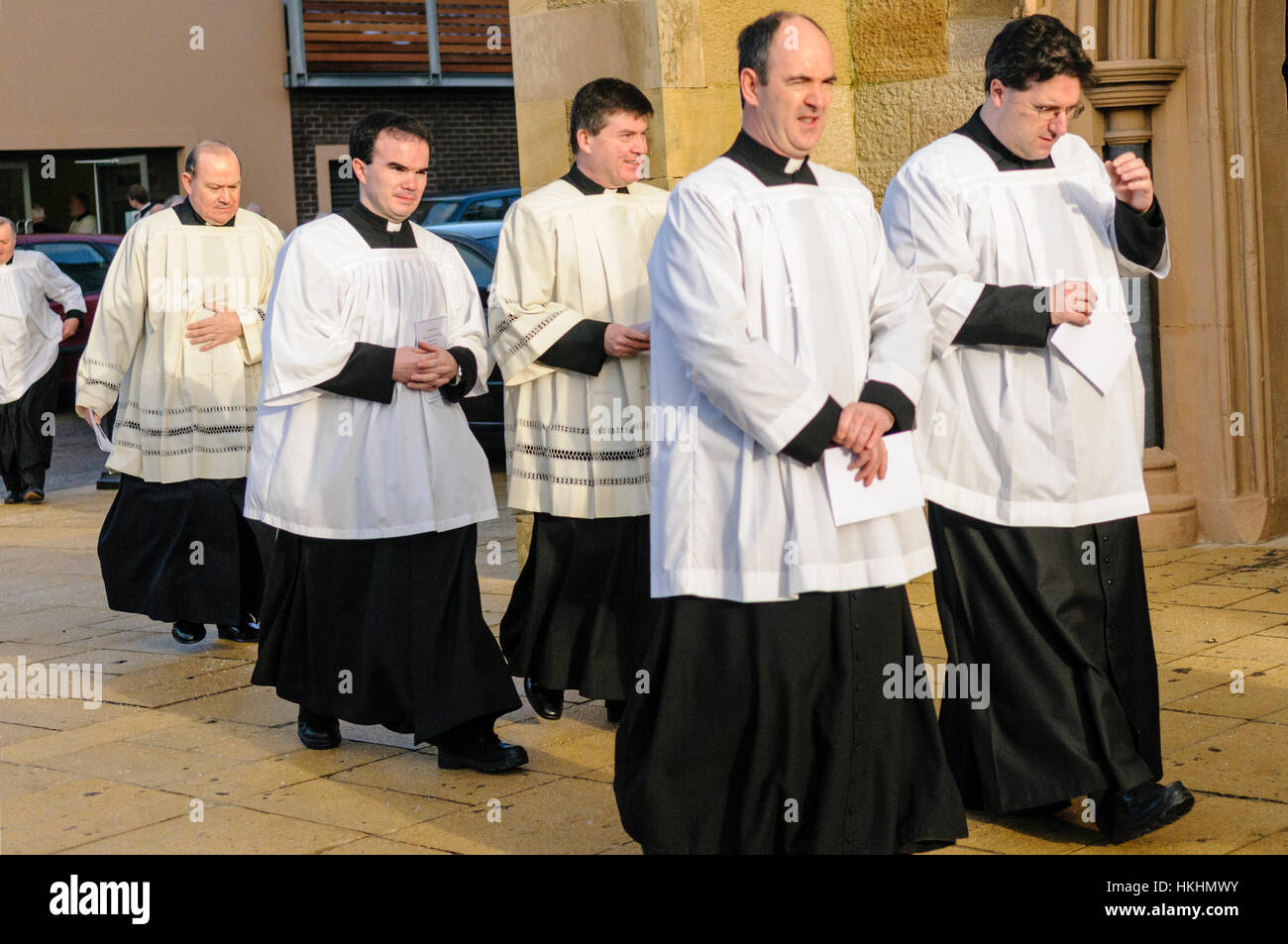 Un numero di sacerdoti di arrivare ad una chiesa per un servizio di massa. Foto Stock