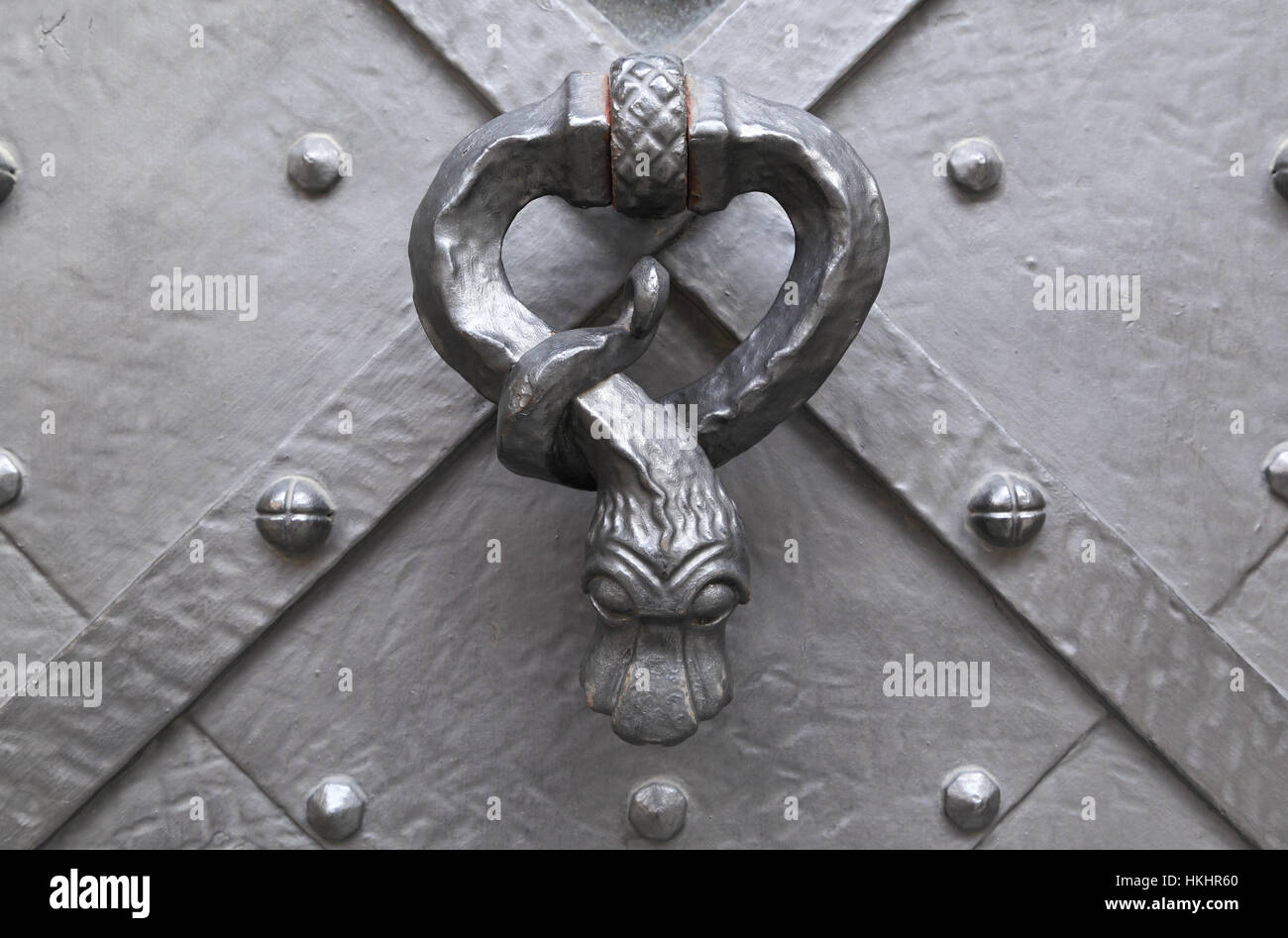 Antica porta di metallo respingente in forma di serpente apposto su un antico porta di metallo. Foto Stock