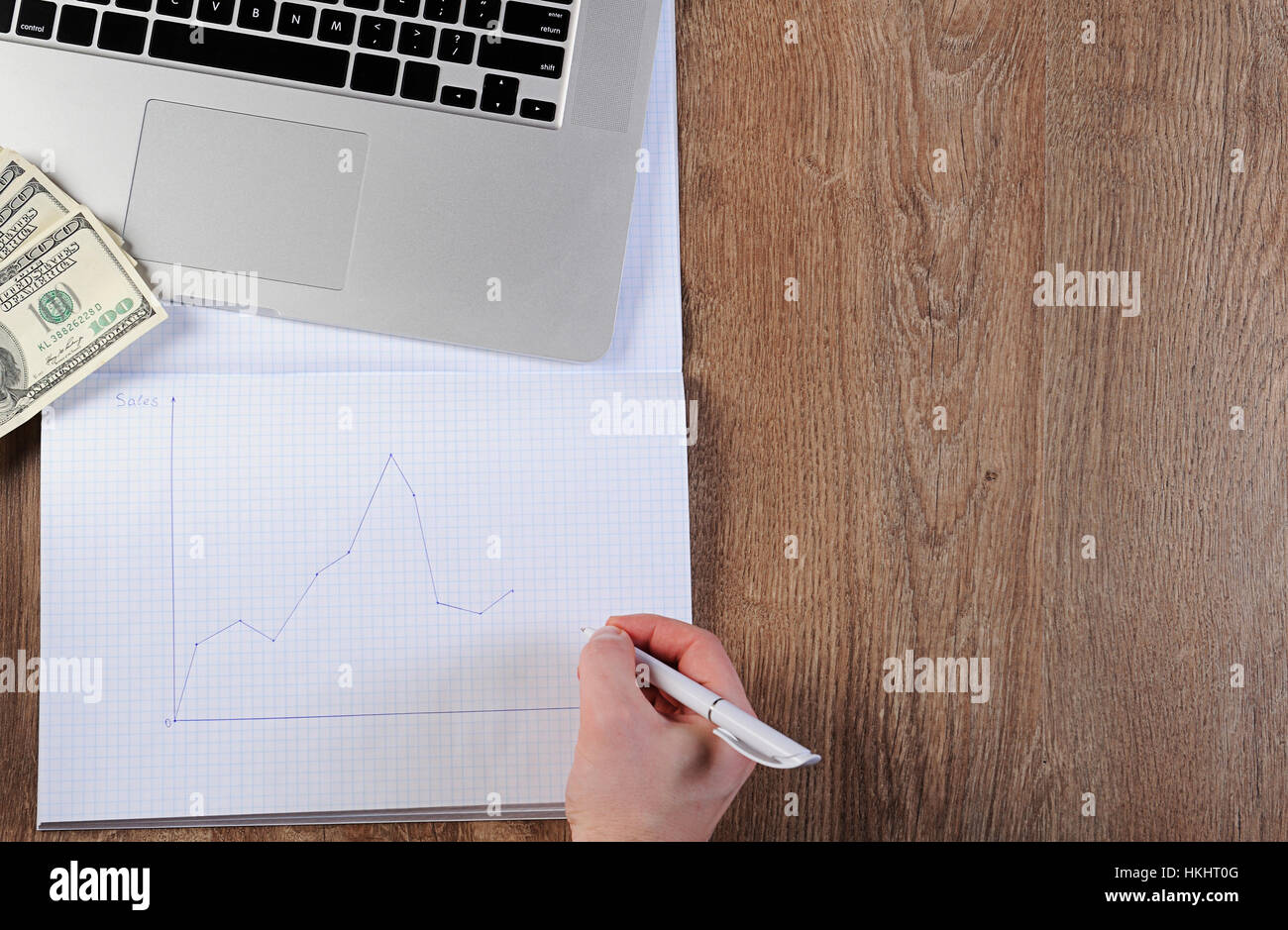 Pianificazione delle finanze schema grafico di dollari denaro sul computer portatile sul tavolo di legno Foto Stock