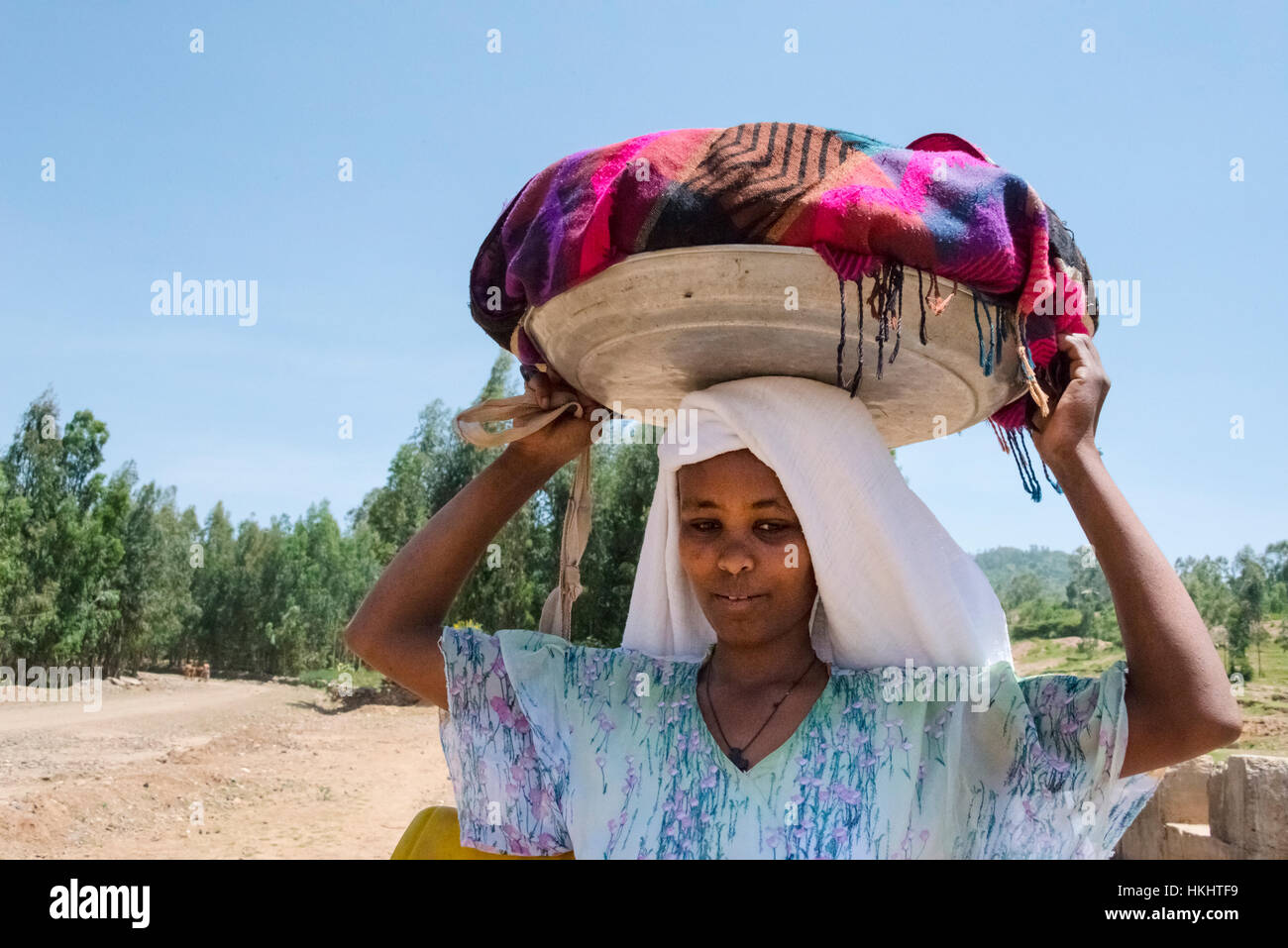Donna cestello di trasporto sulla testa, Aksum, Etiopia Foto Stock