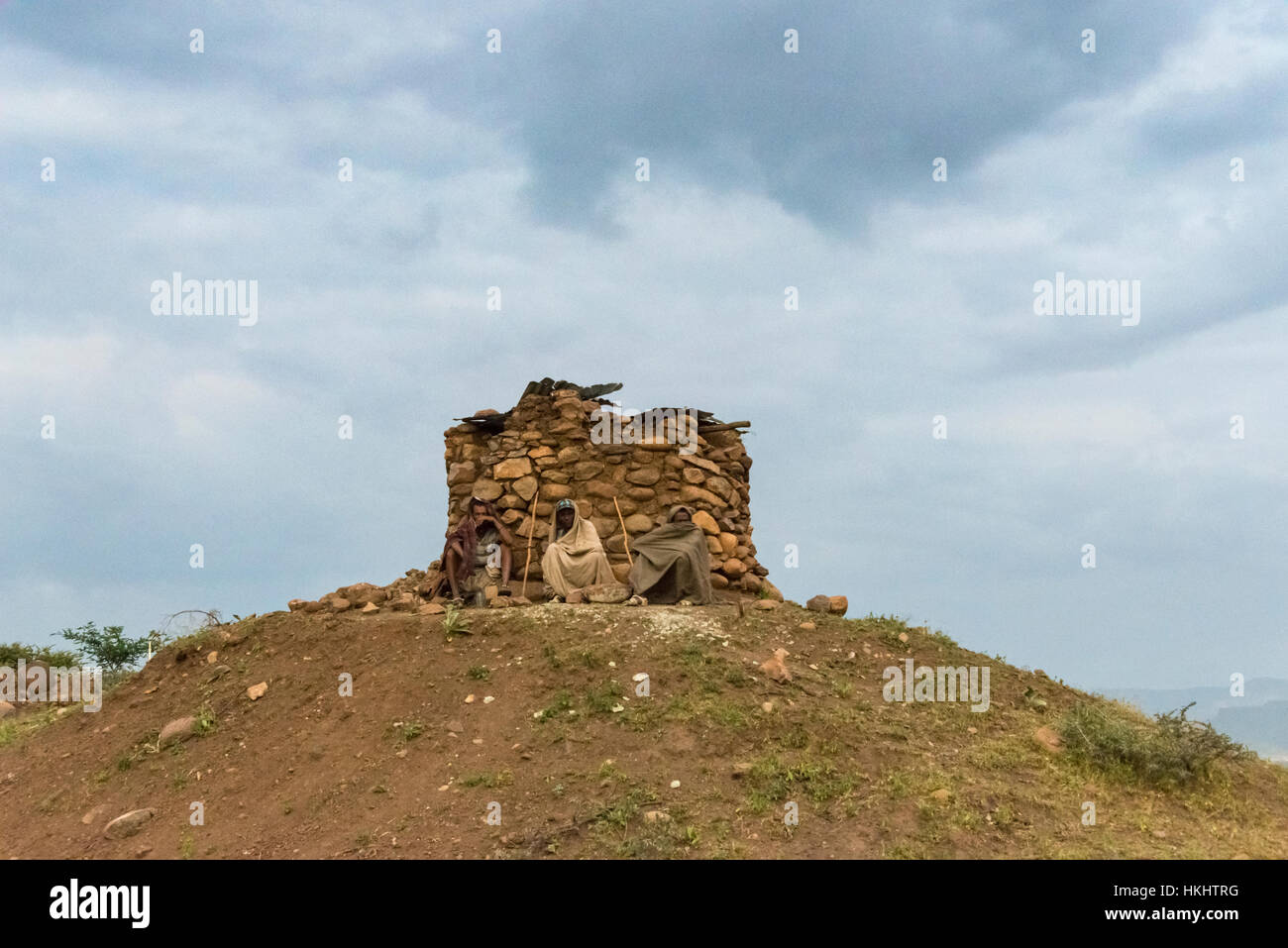 Gli agricoltori appoggiata dai resti di una casa, Lalibela, Etiopia Foto Stock