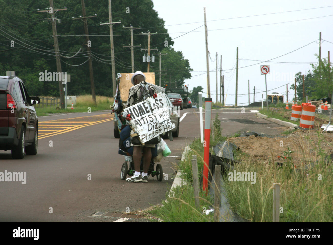Uomo senza tetto che offre il suo servizio di assistenza sulla strada Foto Stock