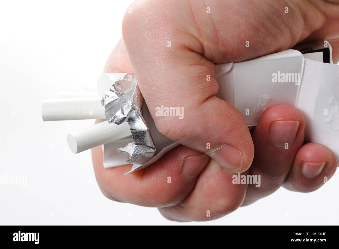 Schiacciare pacchetto di sigarette con pugno isolato su bianco Foto Stock