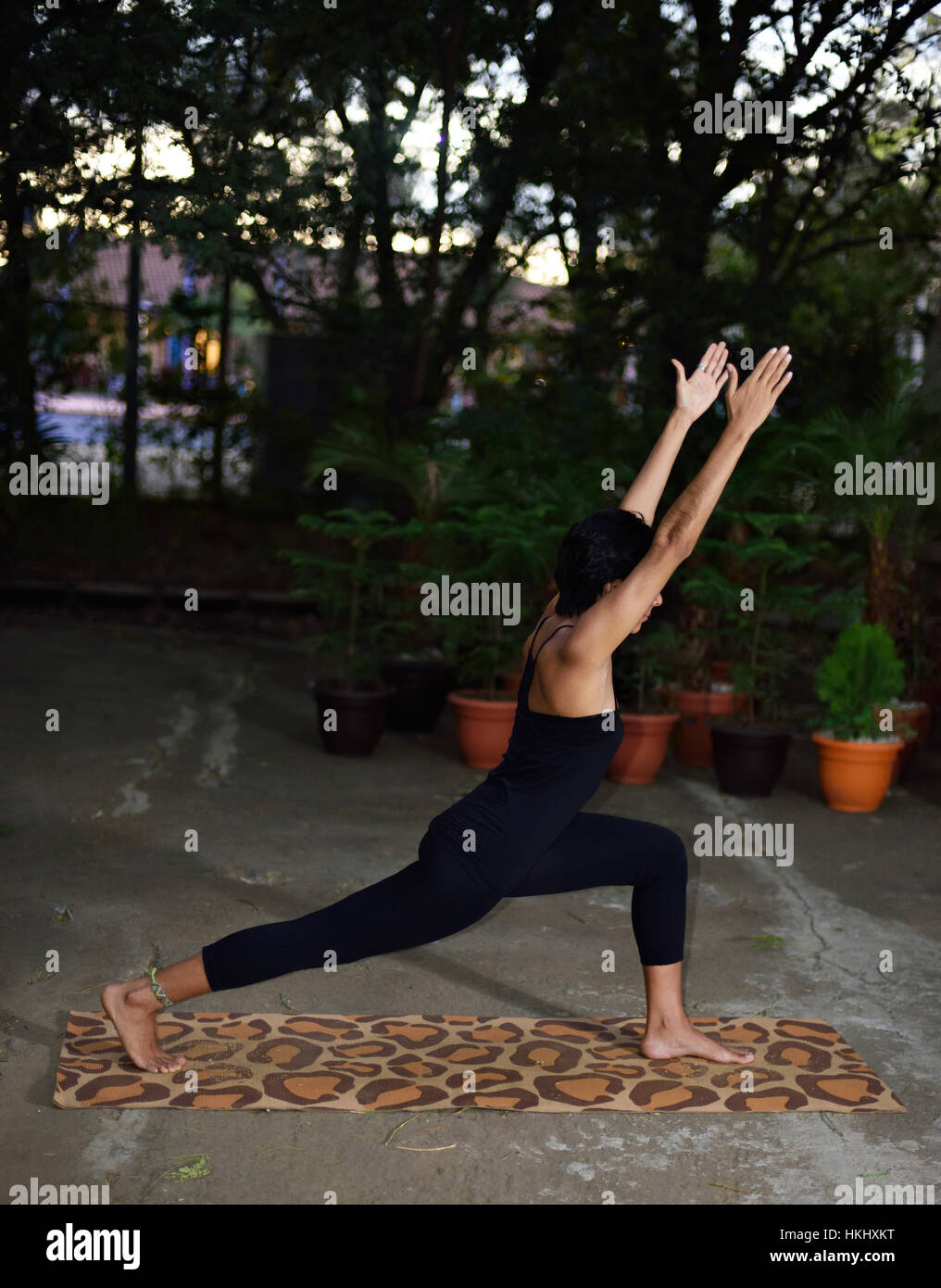 Latino la ragazza mostra lo yoga pone nel giardino della sera Foto Stock