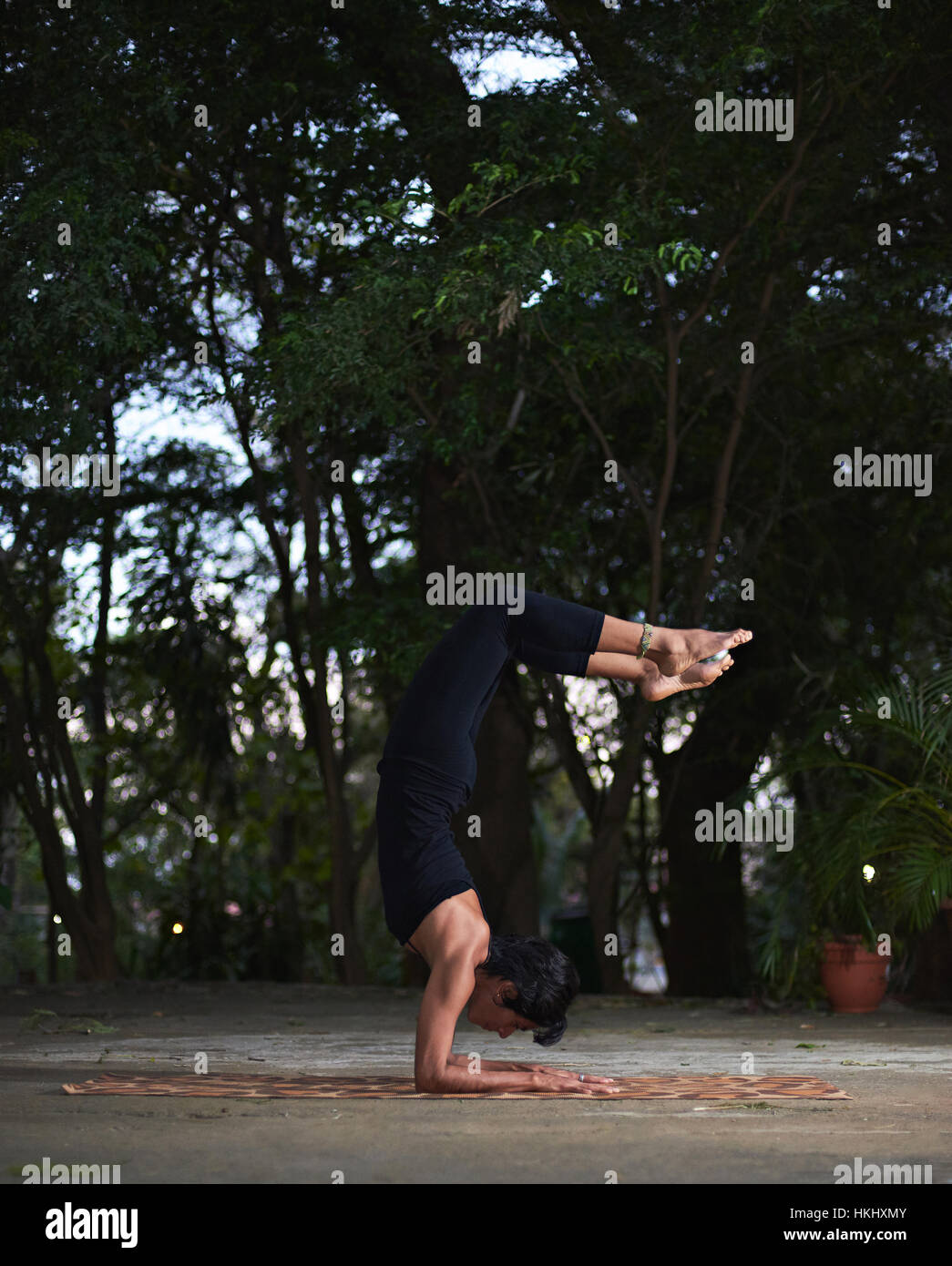 Ragazza facendo yoga nel giardino della sera Foto Stock