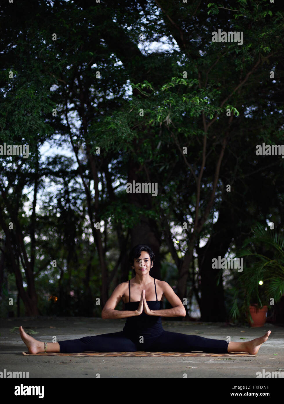 Lo yoga ragazza facendo split nel giardino di mattina Foto Stock