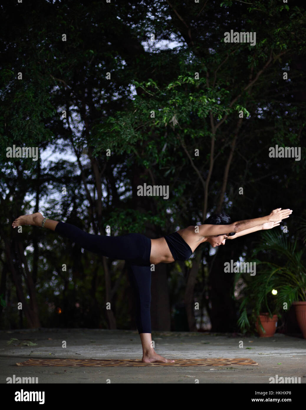 Latino ragazza yog stand su un piede in giardino Foto Stock