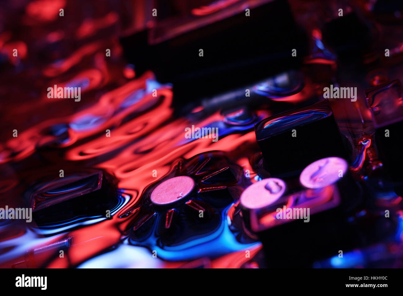 Primo piano di hardware elettronico. assemblaggio sulla scheda a circuito stampato con il rosso e il blu di riflessione concettuale associazione creativa Foto Stock