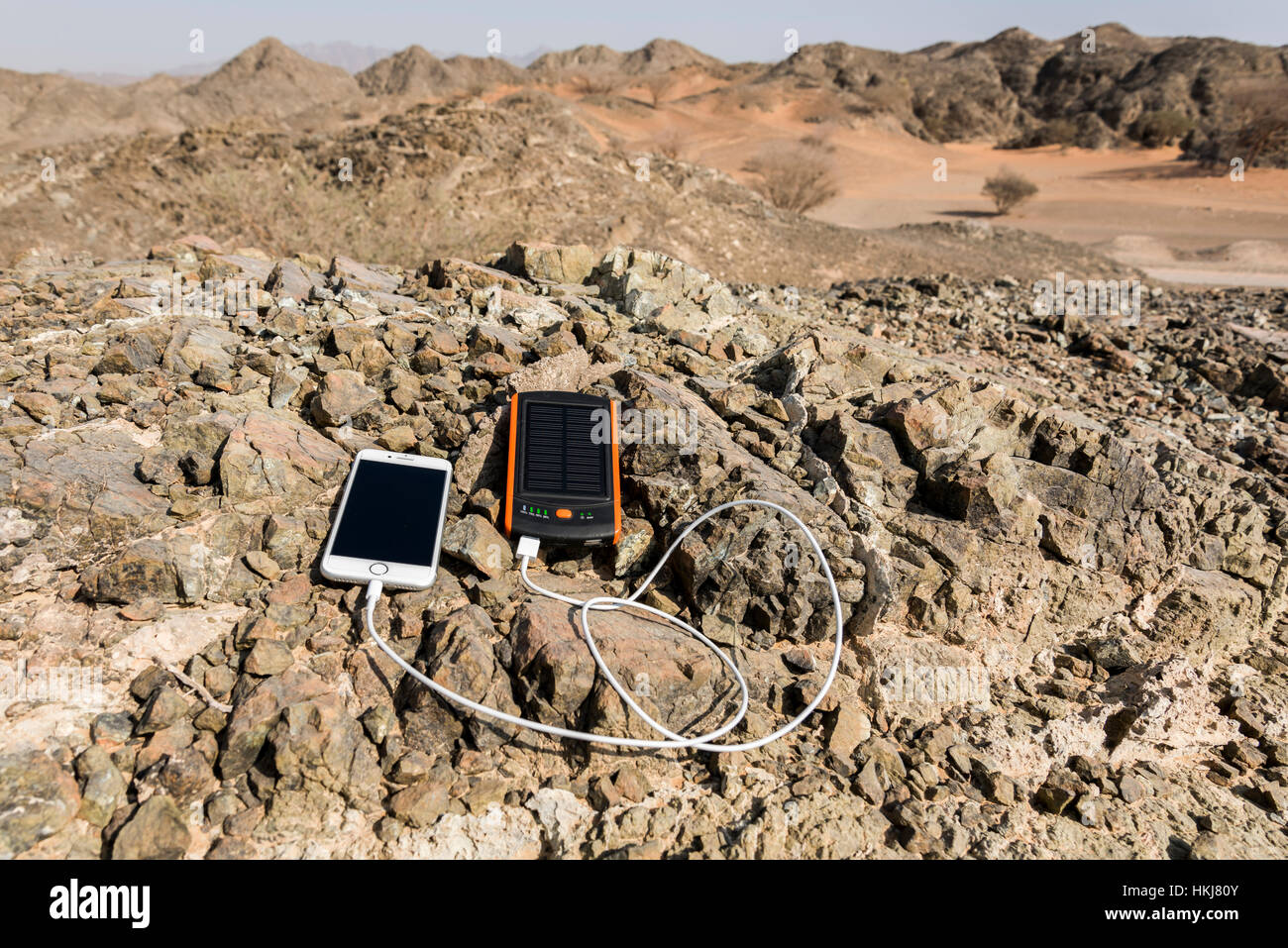 La ricarica dello smartphone con energia solare banca con doppia porta USB con Rocky Mountain come sfondo Foto Stock