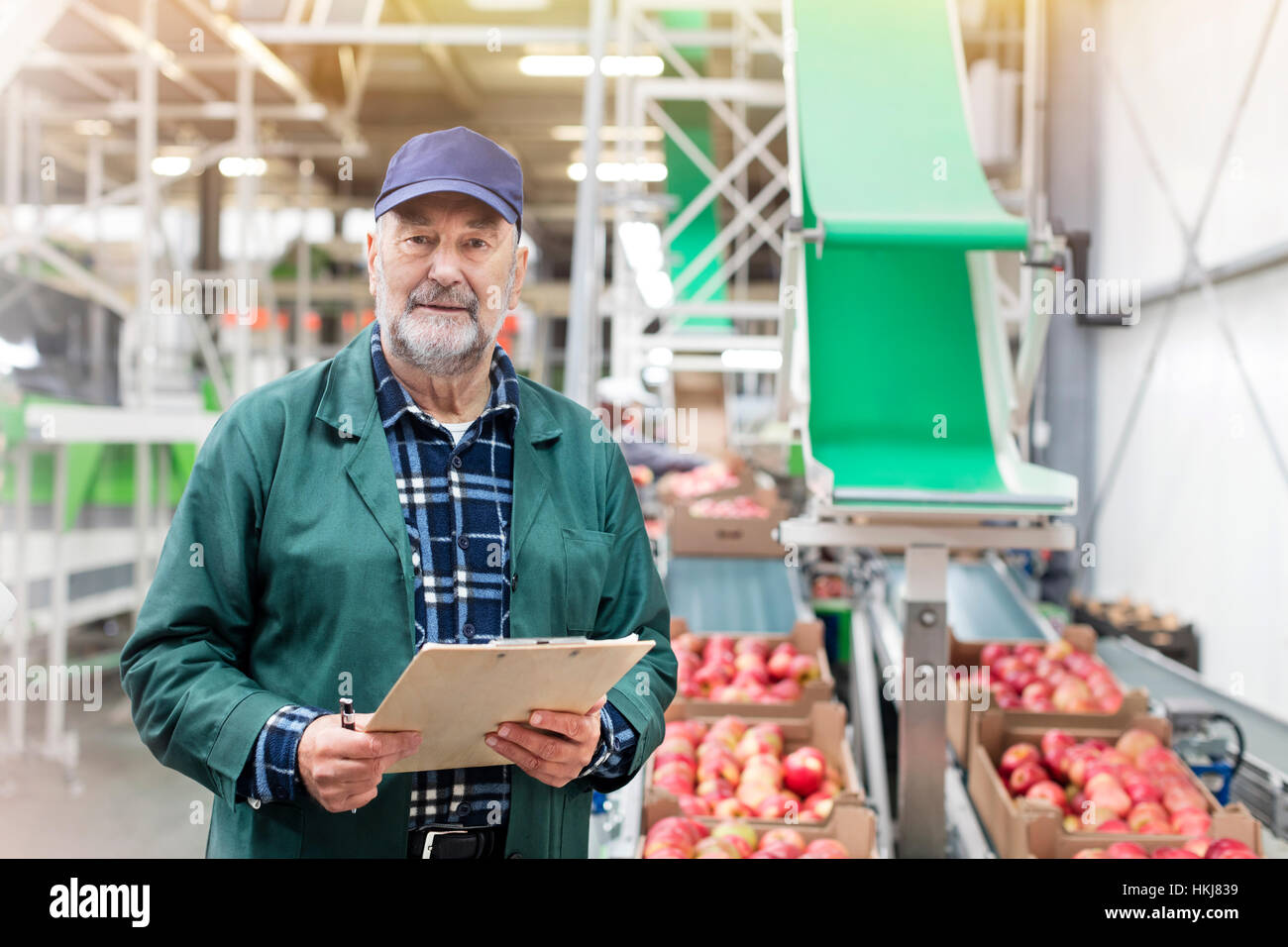 Ritratto fiducioso manager con appunti in apple stabilimento di trasformazione alimentare Foto Stock