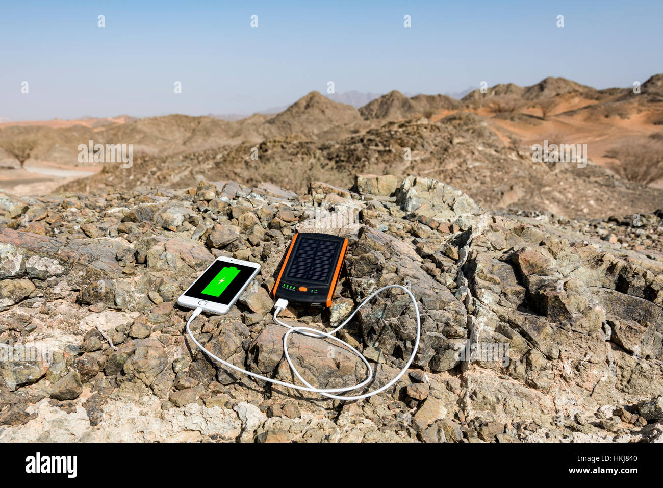 La ricarica dello smartphone con energia solare banca con doppia porta USB con Rocky Mountain come sfondo Foto Stock