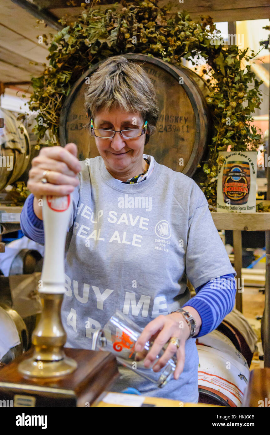 Una donna tira una pinta a una campagna per Real Ale festival. Foto Stock