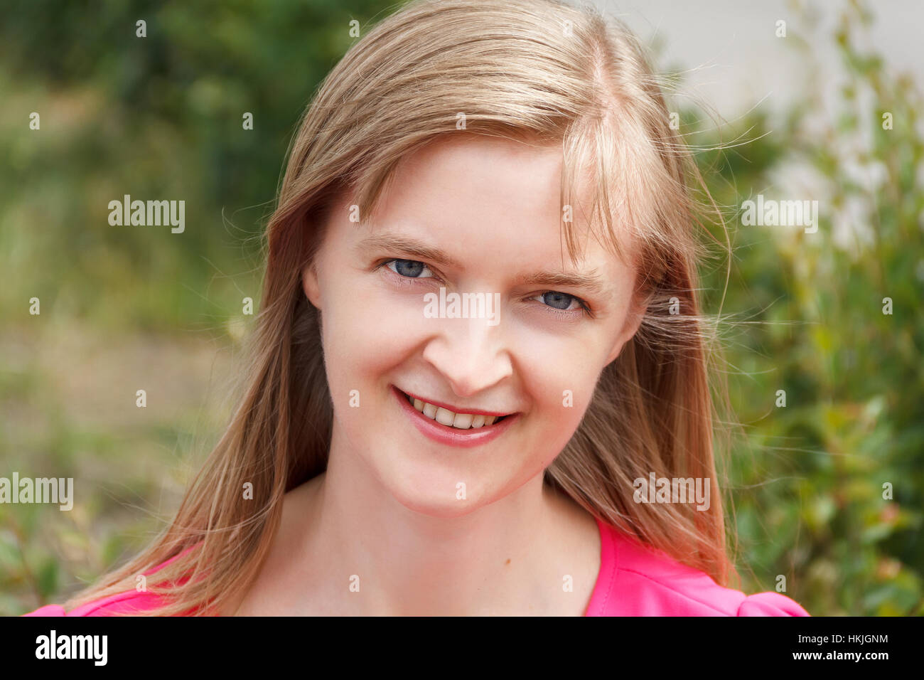 Bionda donna sorridente con i capelli lunghi in estate Foto Stock