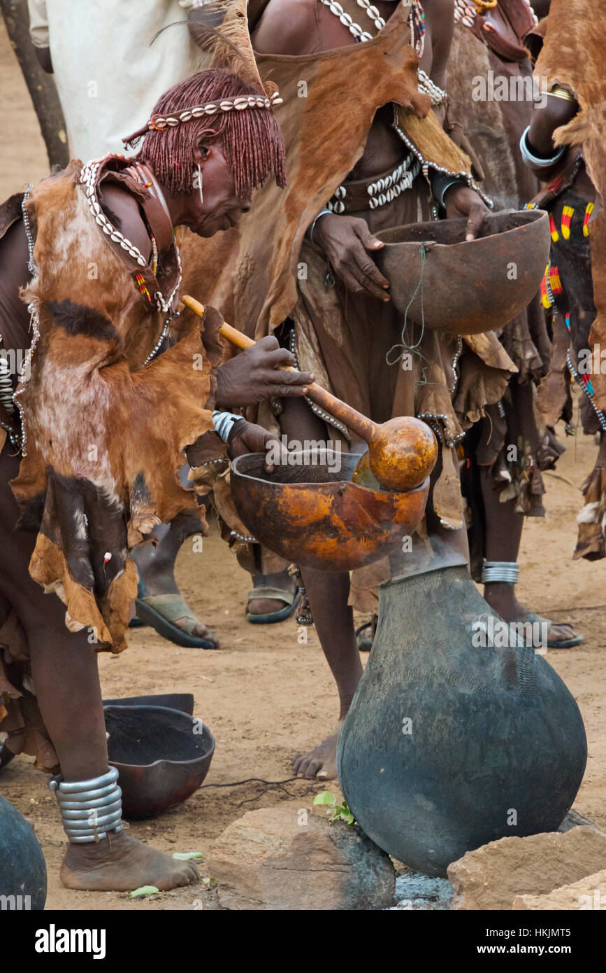 Hamar tribù persone bere vino a bovini Jumping in Hamar Village, Sud Omo, Etiopia Foto Stock