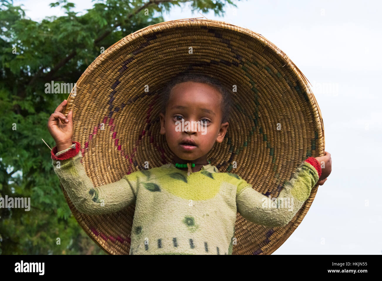 Ragazzo che indossa il coperchio di injera pane piatto contenitore, Addis Abeba, Etiopia Foto Stock