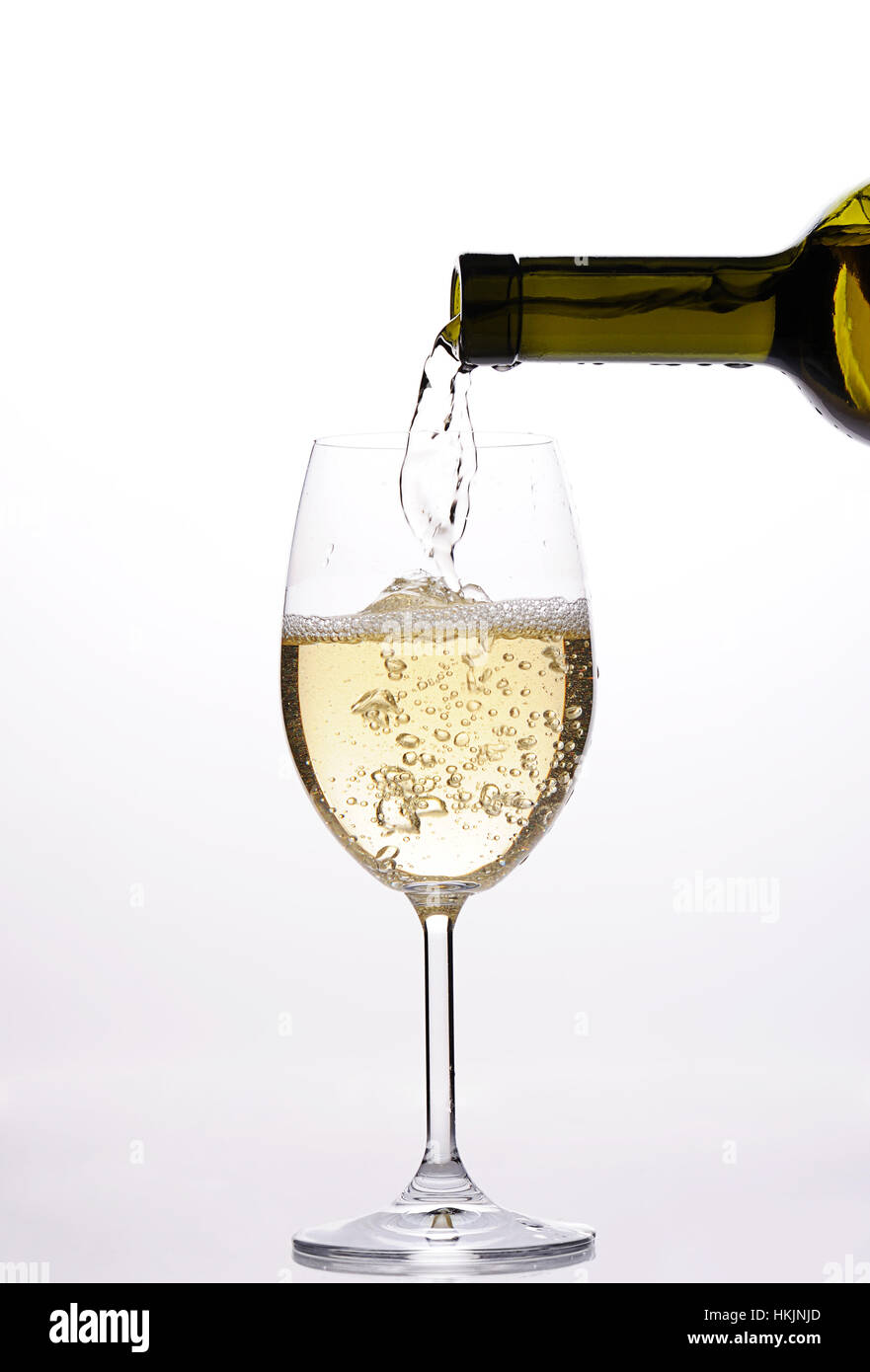 Versare il vino bianco con gocce e sparkle da bottiglia Foto Stock