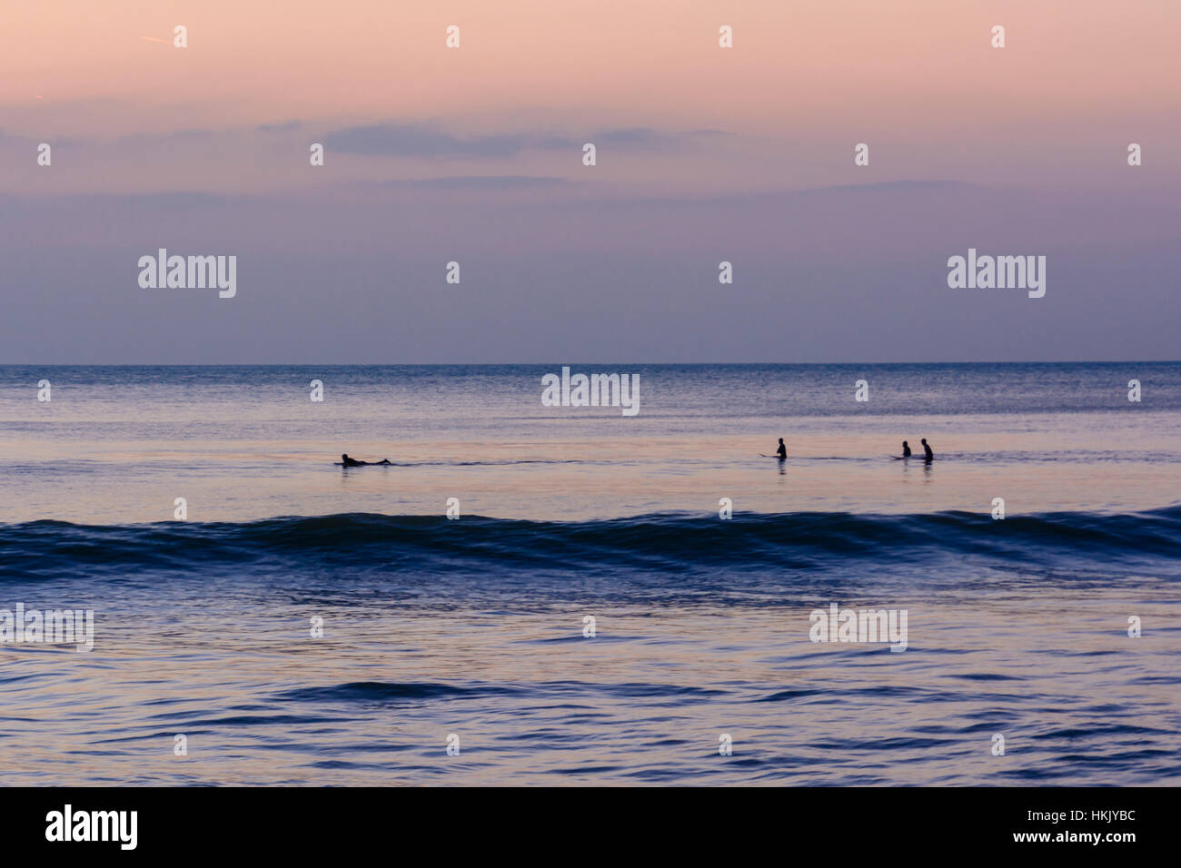 Agli studenti di navigare nel mare di Aberystwyth in al tramonto in inverno Foto Stock