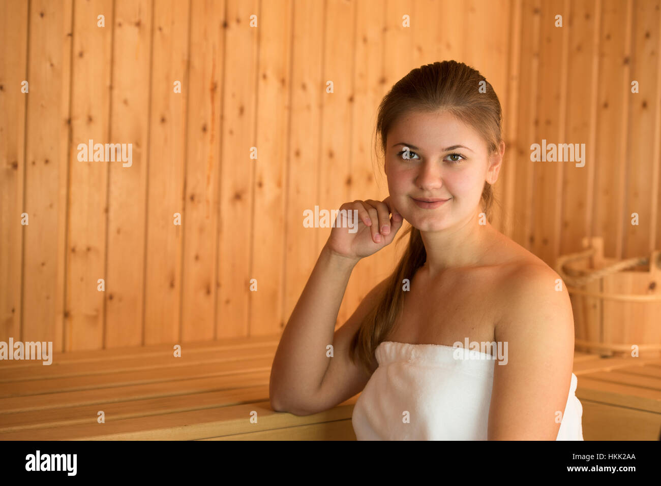 Giovane donna bionda in sauna in legno Foto Stock