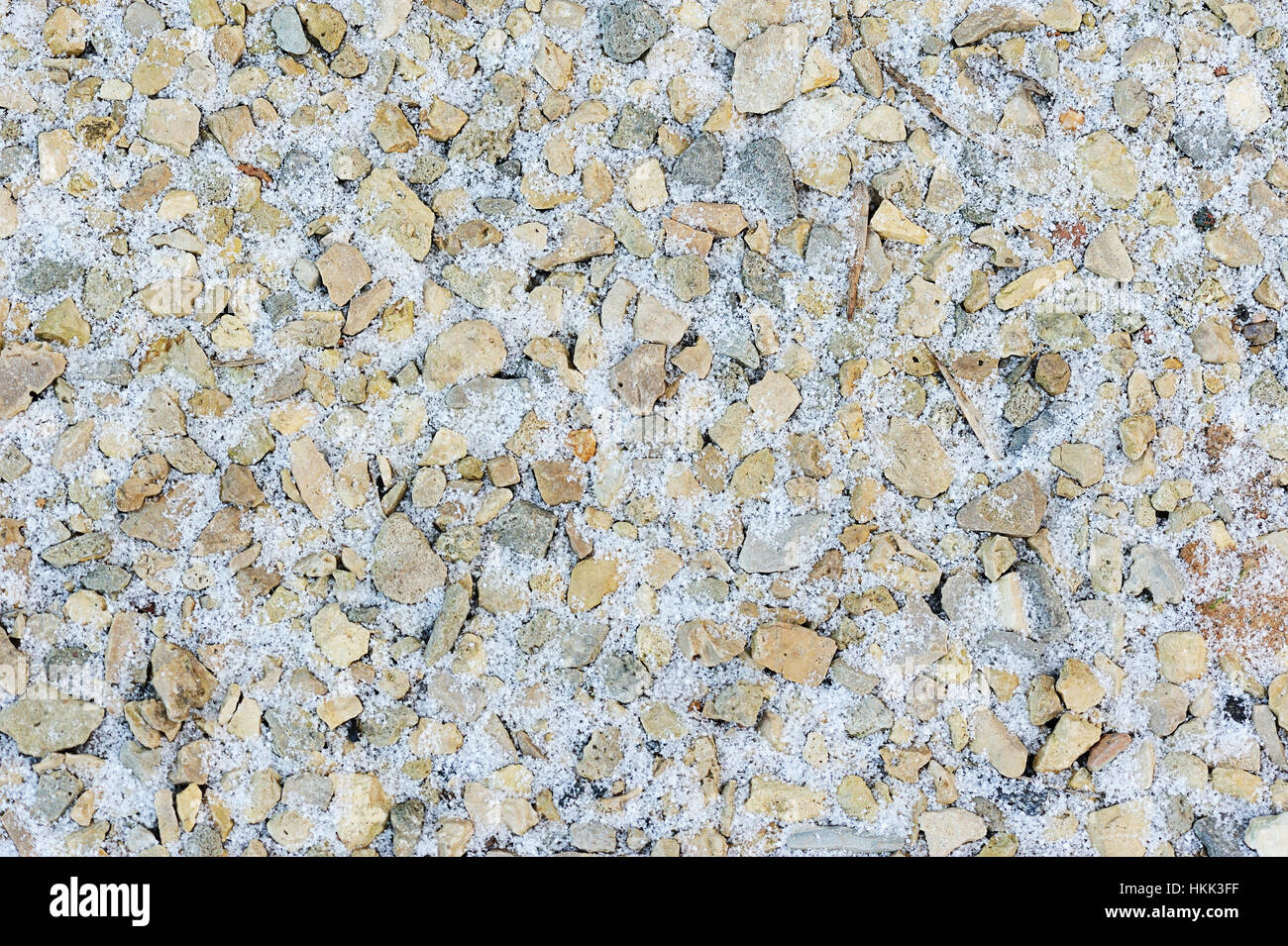 Neve intorno a piccole pietre di colore giallo in inverno Foto Stock