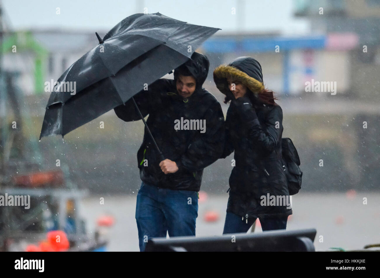 West Bay, Dorset, Regno Unito. Il 29 gennaio 2017. Regno Unito Meteo. Un giovane alle prese con un ombrello al vento forte come heavy rain falls a West Bay nel Dorset. Credito Foto: Graham Hunt/Alamy Live News. Foto Stock