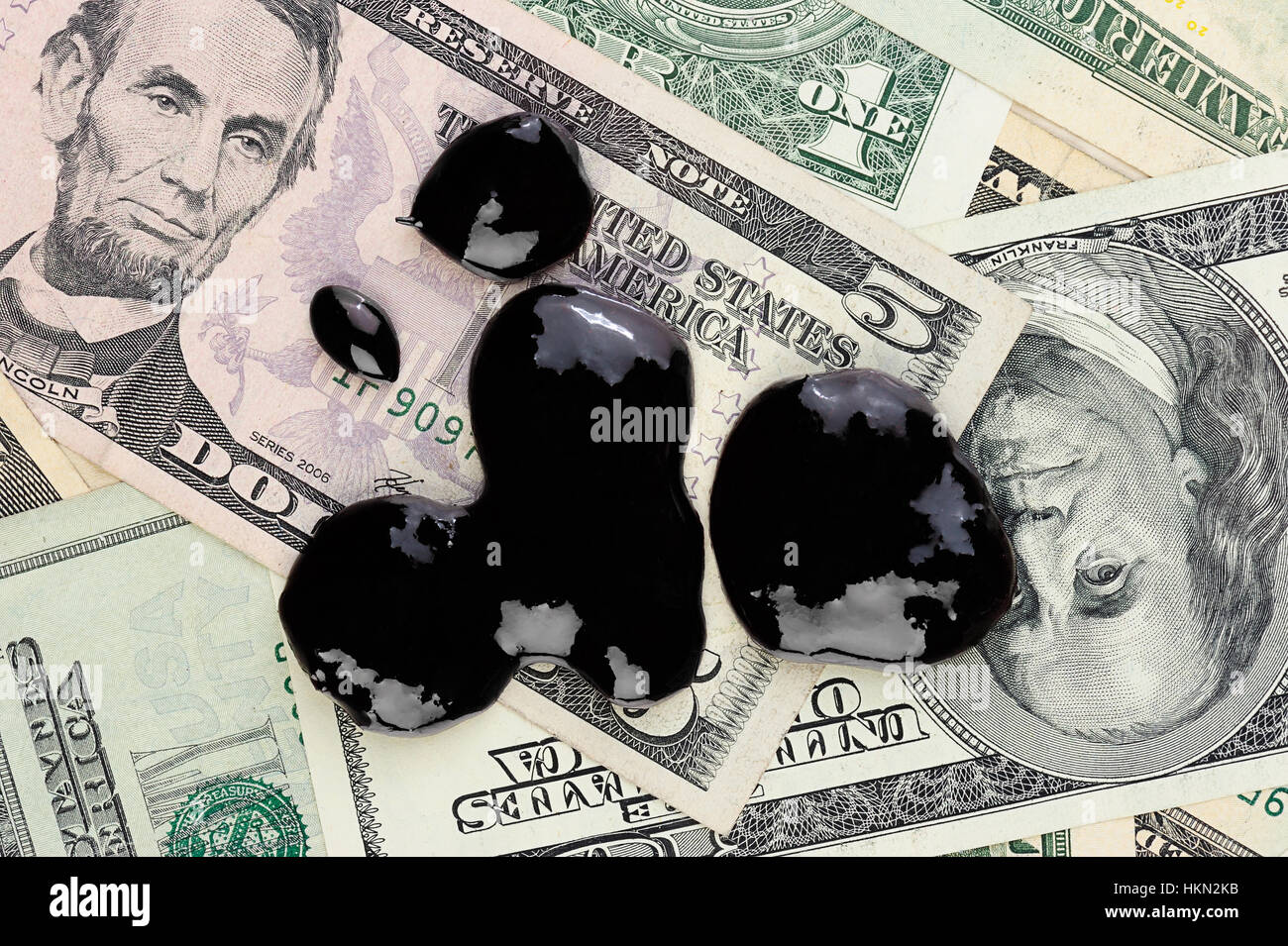 Gocce di olio e benzina sul dollaro superiore denaro Foto Stock