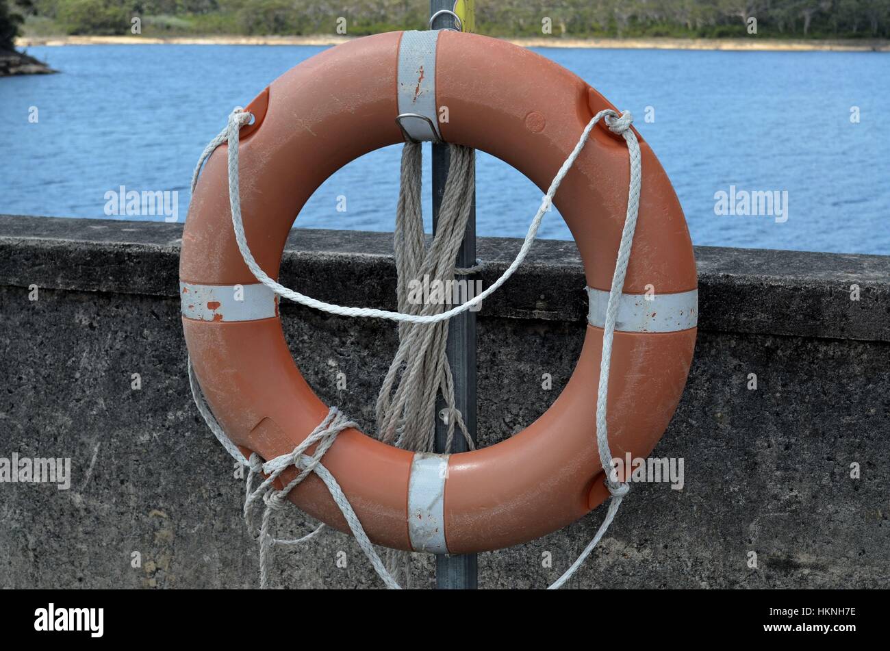 Salvagente sulla diga di pietra arenaria parete Foto Stock