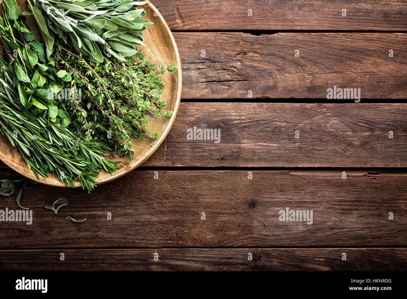 Varie erbe fresche, rosmarino, timo, menta e salvia su sfondo di legno Foto Stock