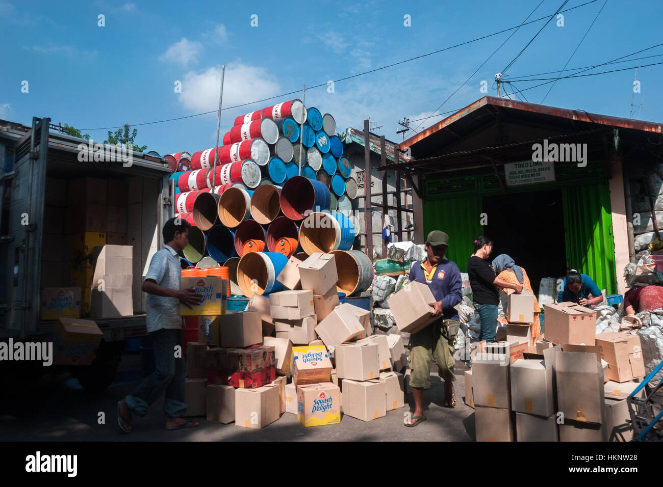Attività dei lavoratori in un negozio di vendita su strada per contenitori di imballaggio usati a Surabaya, Giava orientale, Indonesia. Foto Stock