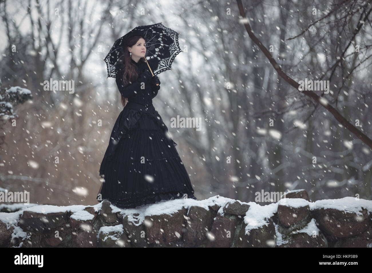 La donna in nero abito vittoriano nel Winter Park Foto Stock