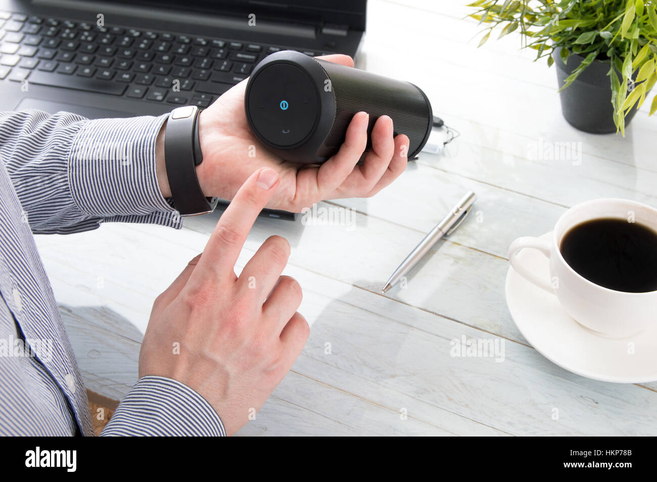 L uomo è svolta sul dispositivo audio wireless per connettersi con il calcolatore. Foto Stock