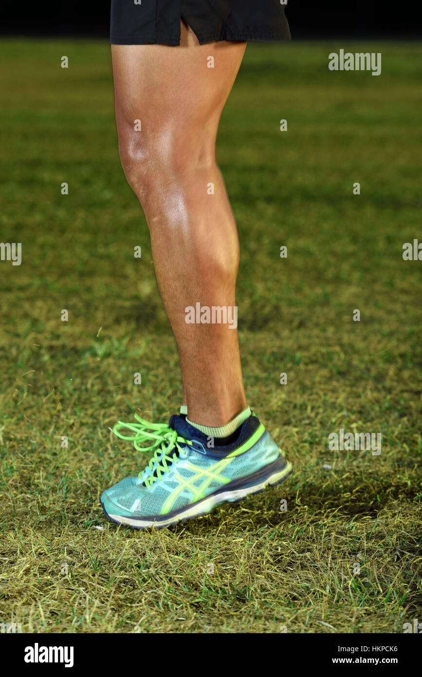 Sport uomo piedi saltando su erba verde park Foto Stock