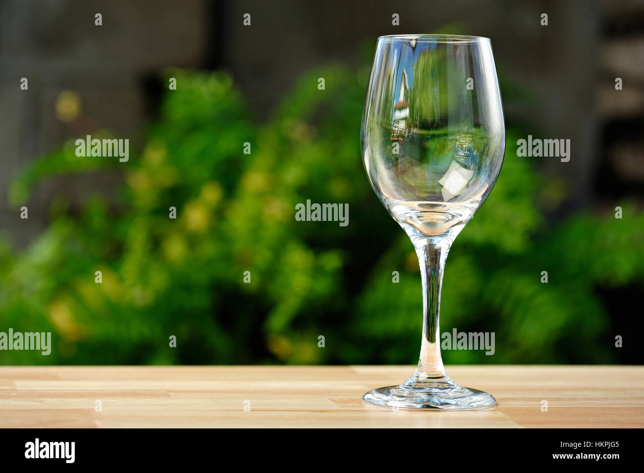 Vuoto in vetro di vino sul tavolo nel parco verde di sfondo Foto Stock