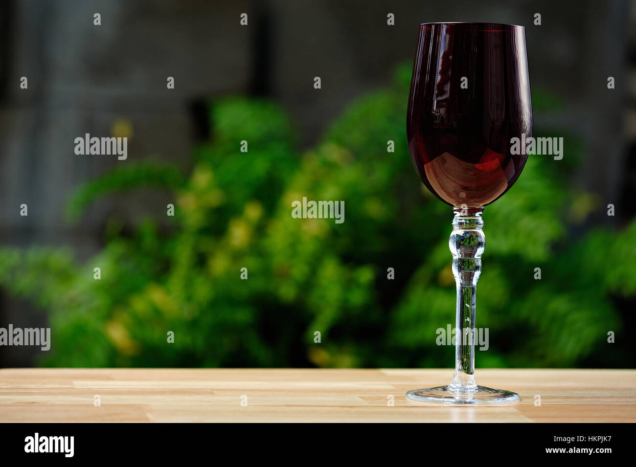 Svuotare il vino rosso bicchiere alto sulla tabella nel parco verde Foto Stock
