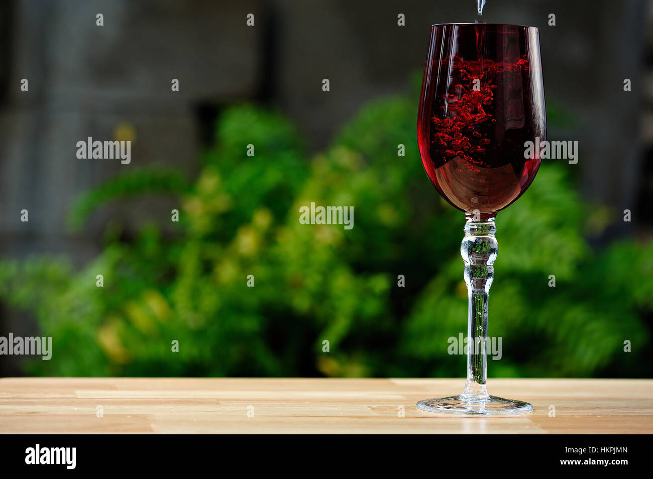 Drink di colata su rosso bicchiere alto nel giardino verde Foto Stock