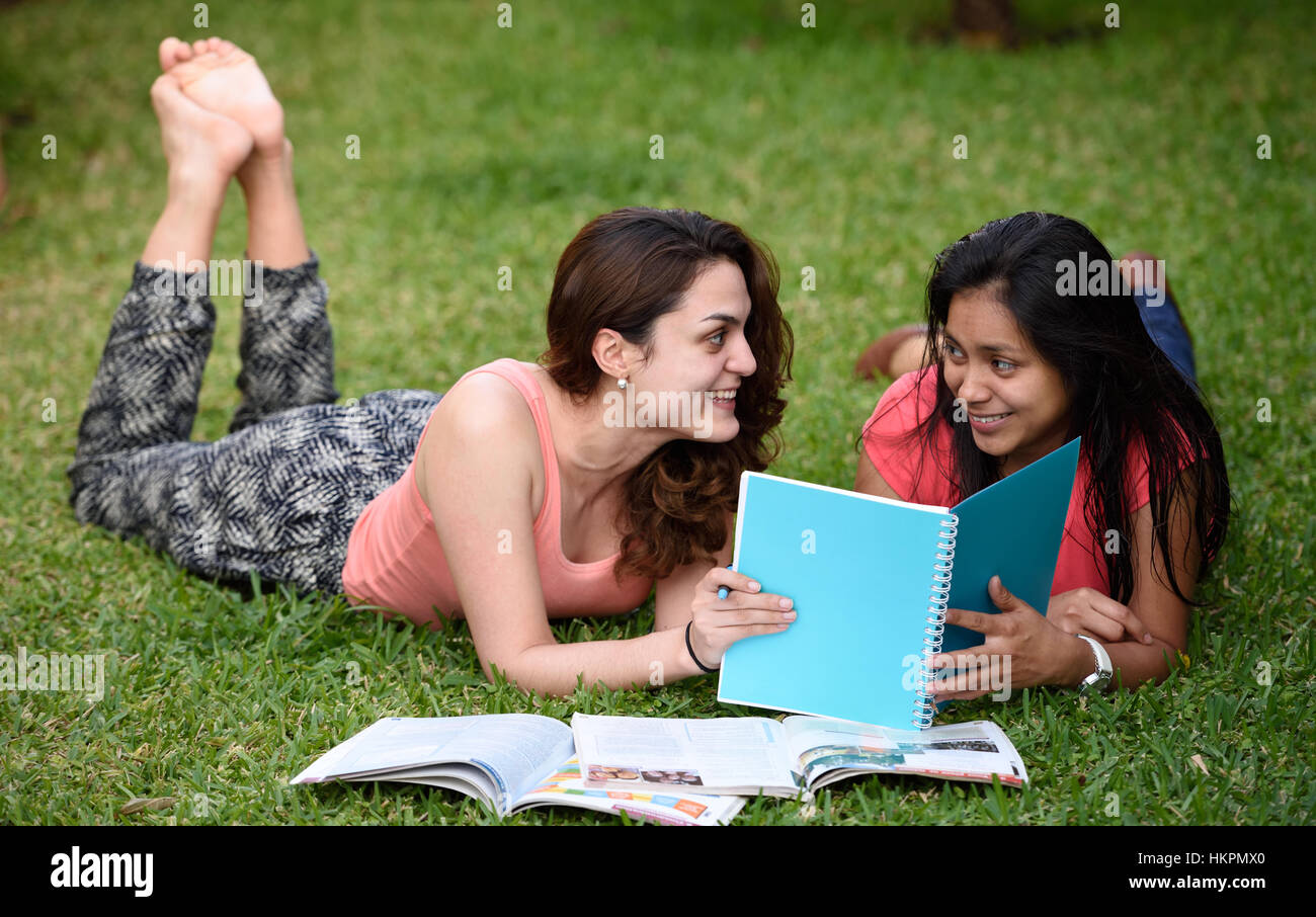 Gli studenti latino ragazze giaceva su erba nel parco Foto Stock