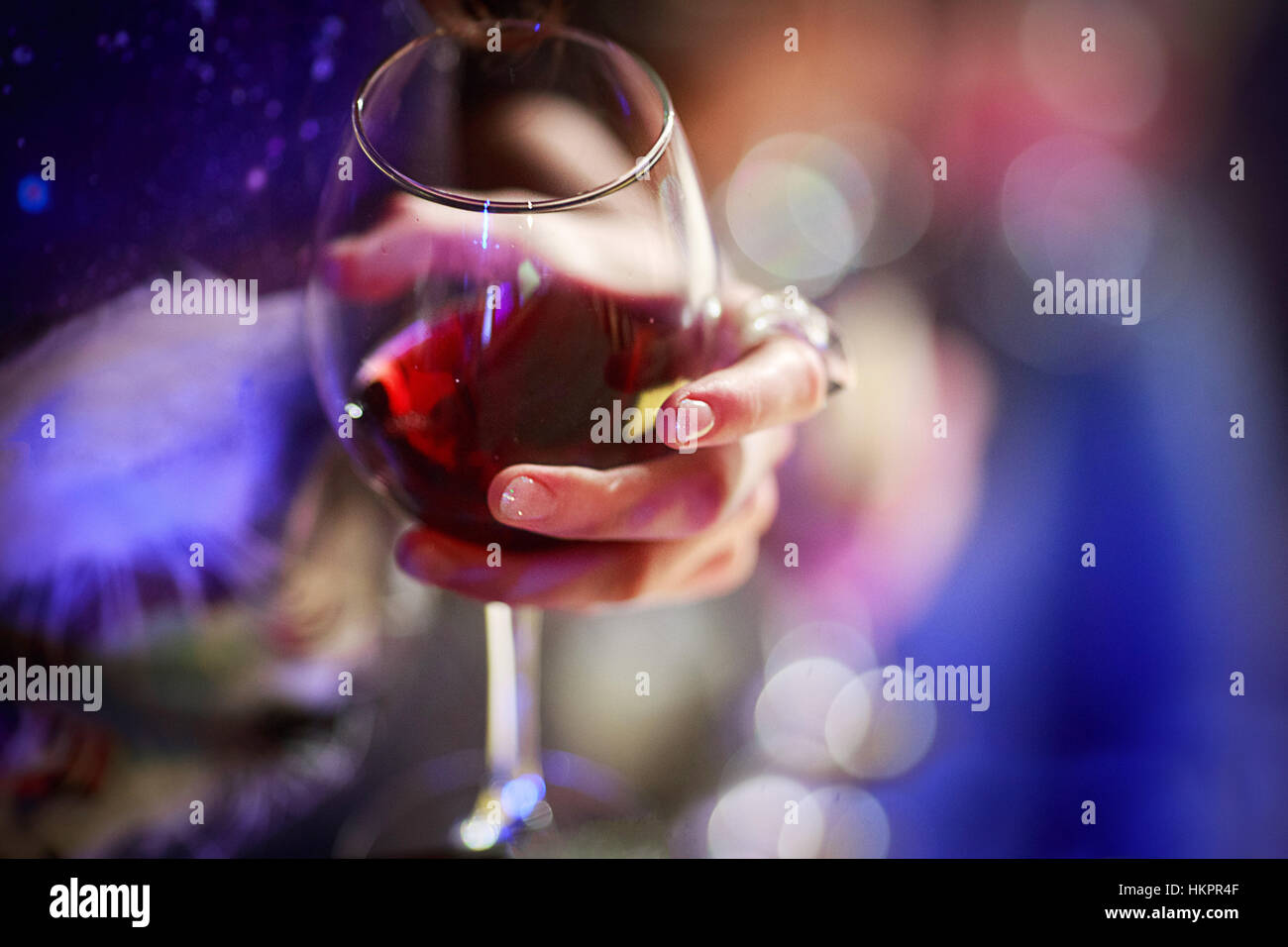 Il vetro con il vino rosso in mano della ragazza di close-up Foto Stock
