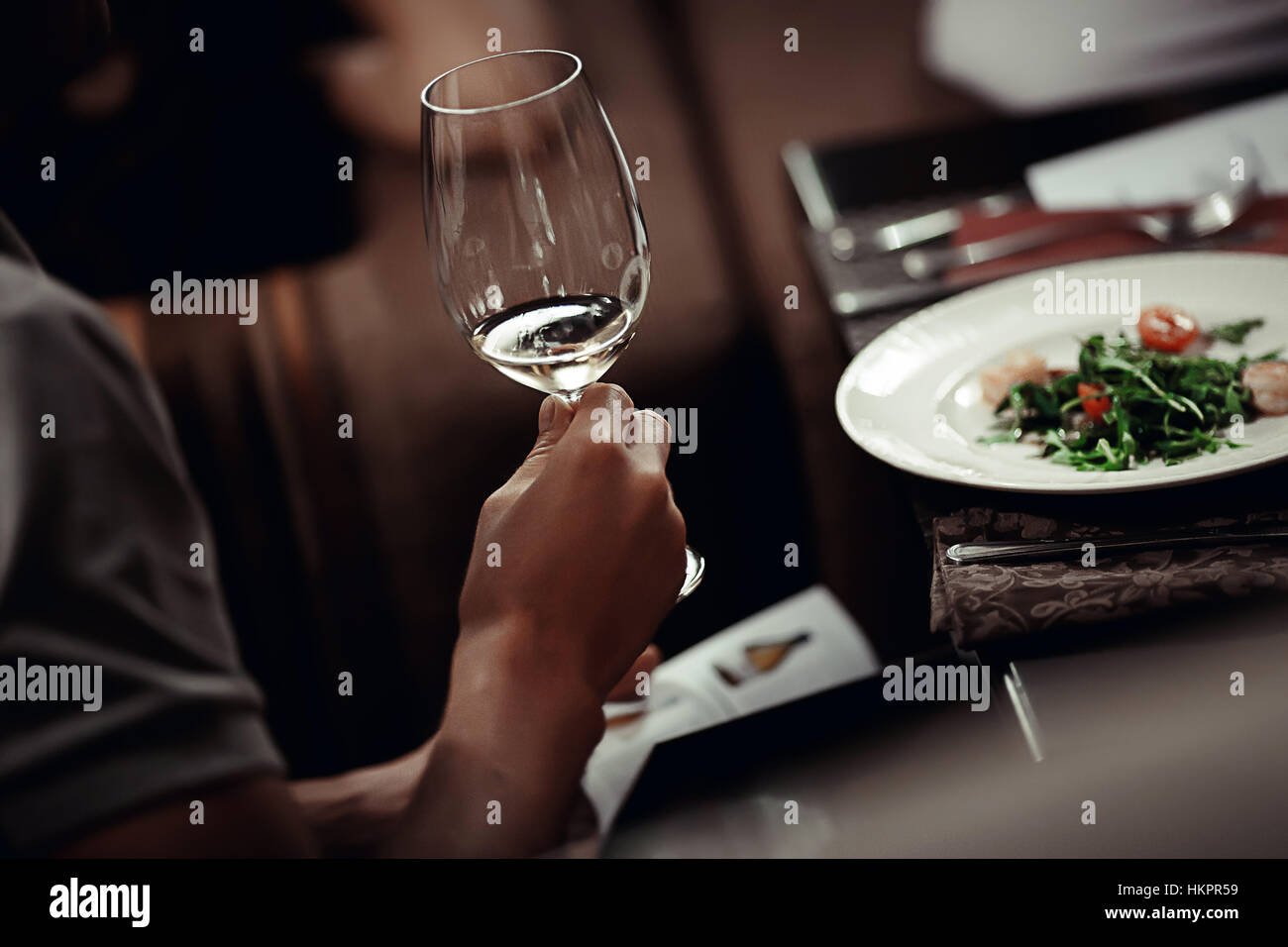 L'uomo con un bicchiere di vino in una mano e menu Foto Stock