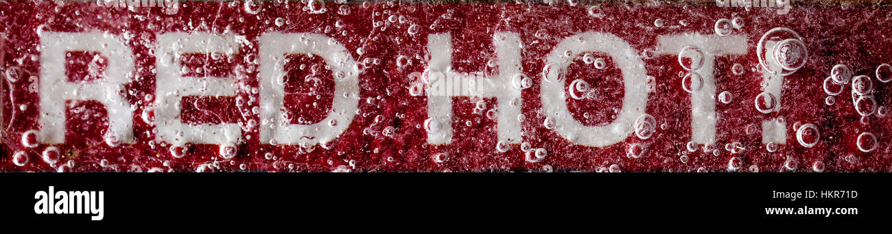 Red Hot testo segno di avvertimento sotto uno strato di ghiaccio con uno sfondo rosso. Foto Stock