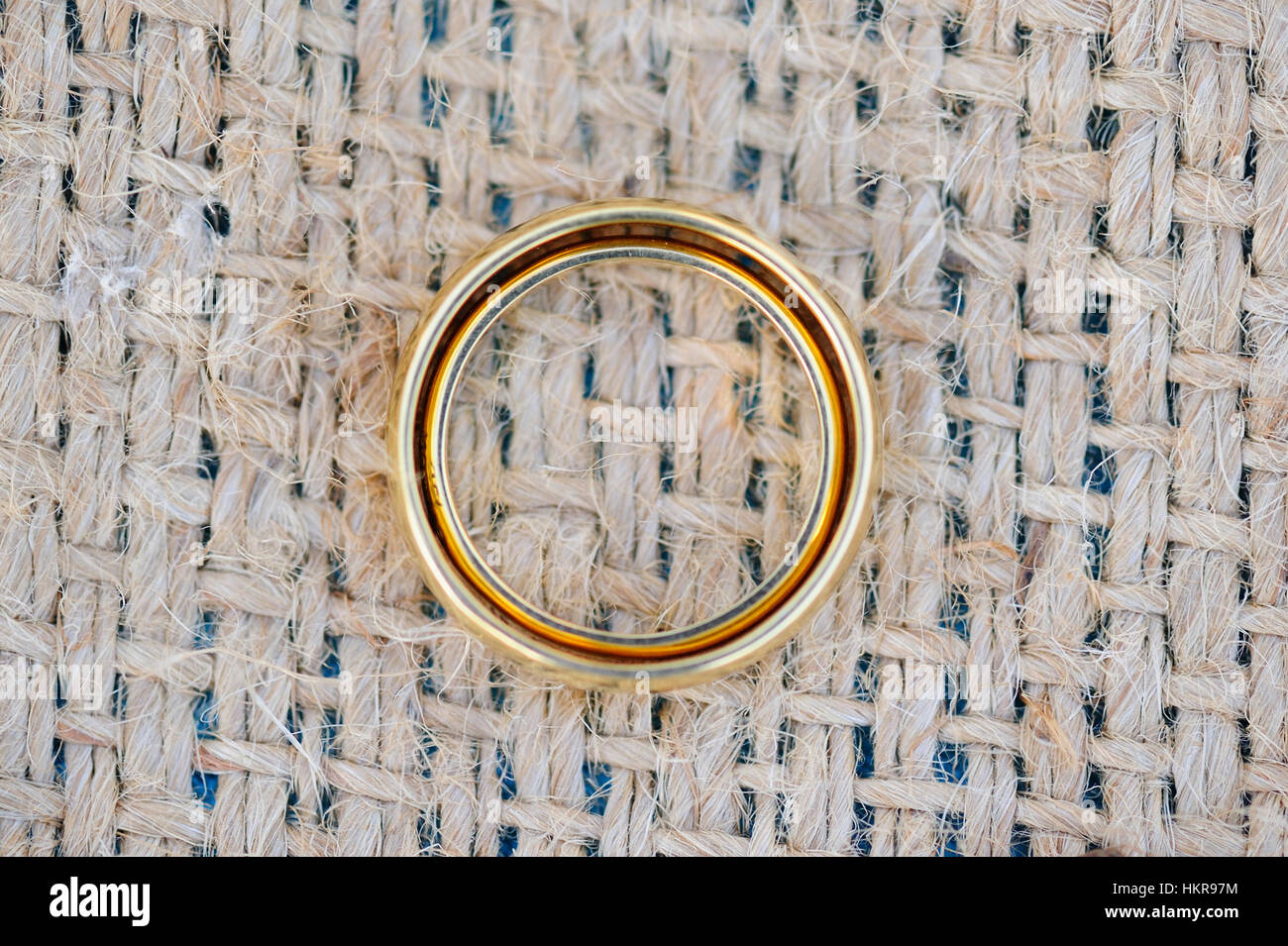 Anelli d oro che stabilisce insieme sulla tavola con lino Foto Stock