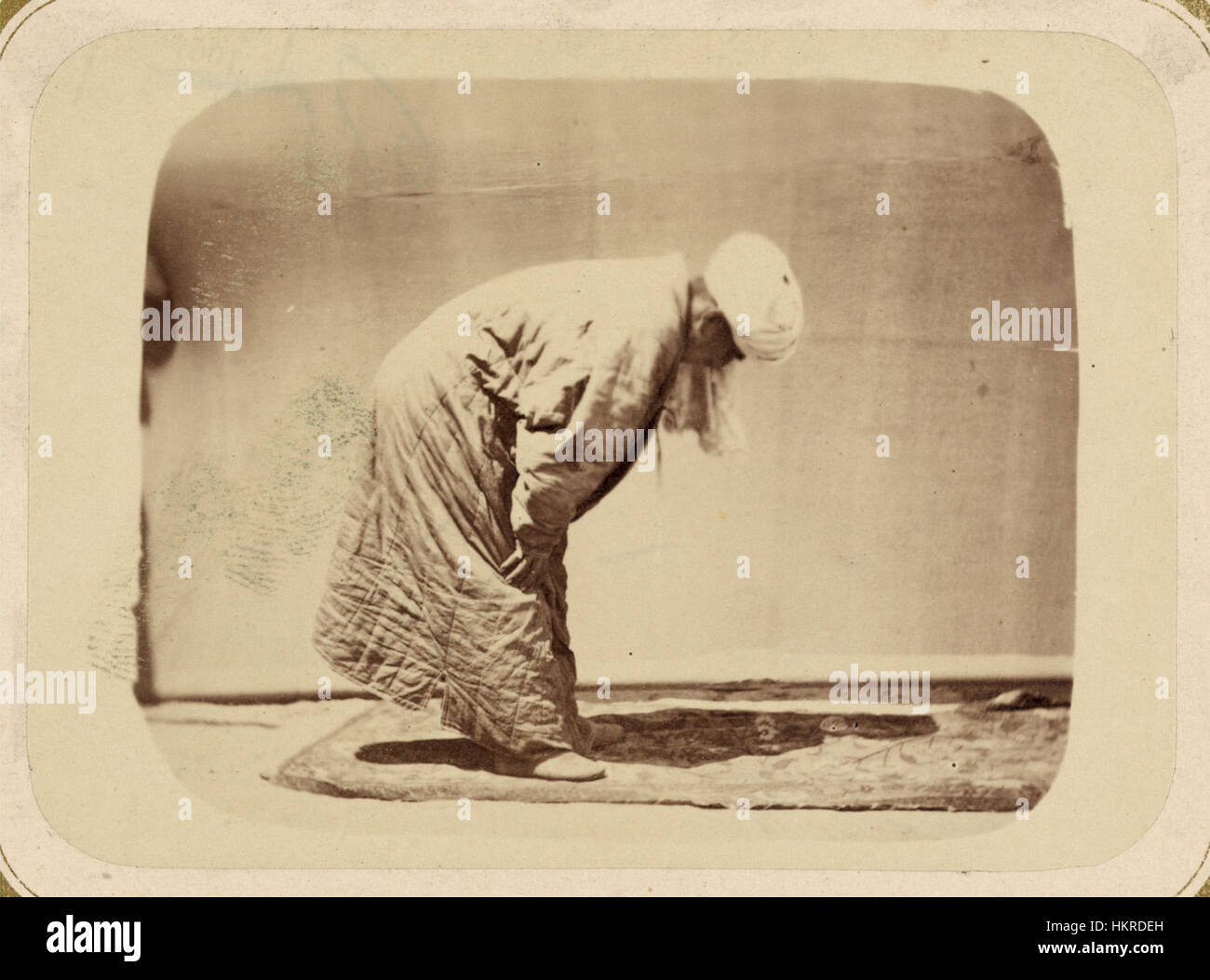 Questa opera d'arte cattura il momento di inginocchiarsi durante la preghiera musulmana, evidenziando uno dei cinque pilastri dell'Islam. Il pezzo sottolinea il significato ritualistico della preghiera nella cultura islamica e il suo ruolo nella pratica spirituale. Foto Stock