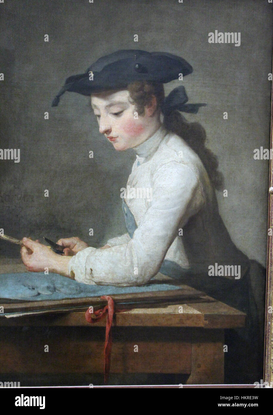 Questo dipinto del 1737 di Jean-Baptiste-Siméon Chardin, intitolato "il giovane disegnatore", mostra un giovane artista focalizzato sul suo disegno, esemplificando l'abilità di Chardin nel ritrarre momenti intimi della vita quotidiana. L'opera è un notevole esempio di realismo francese del XVIII secolo. Foto Stock