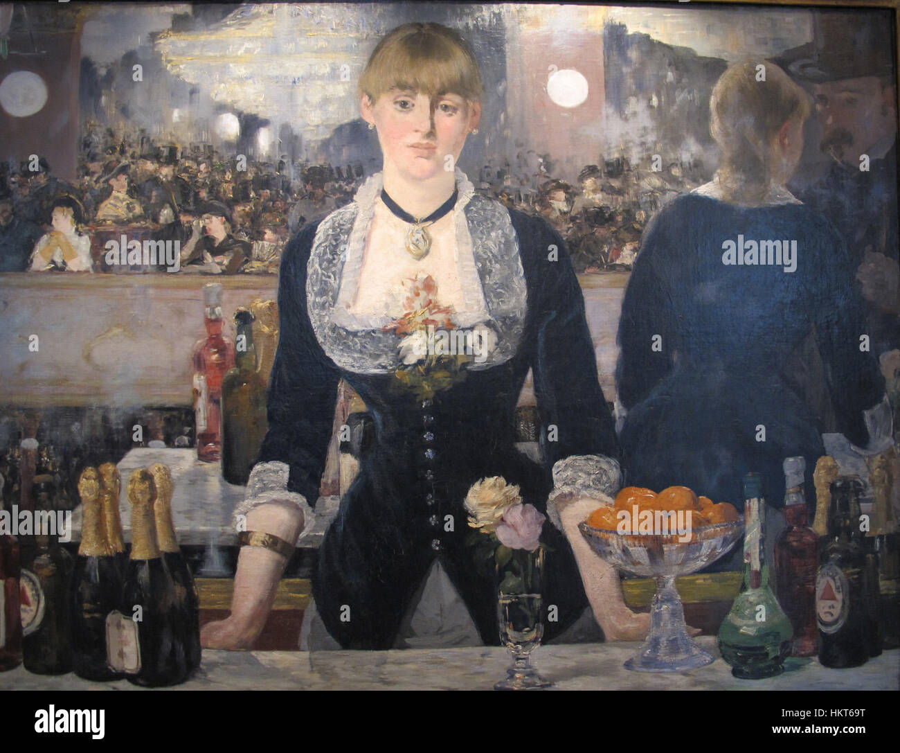 Questo iconico dipinto di Édouard Manet, intitolato "Un bar alle Folies-Bergère", raffigura una scena all'interno del famoso cabaret parigino. La composizione ritrae una cameriera con una superficie riflettente, catturando l'atmosfera della vita notturna parigina del XIX secolo. Foto Stock