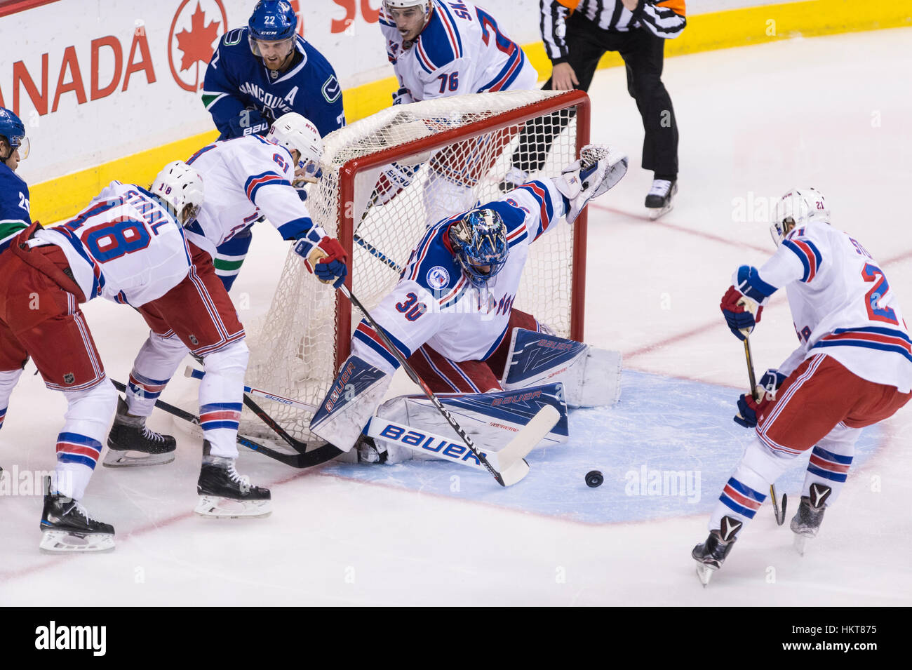 I giocatori della difesa di un puck allentata nella parte anteriore del Goalie Henrik Lundqvist del New York Rangers, Rogers Arena Vancouver British Columbia. Foto Stock